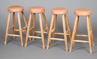 Four turned elm stools with upholstered leather seats, raised on turned supports 71cm h x 29cm diam. 