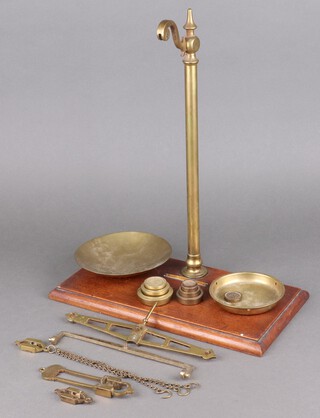 A set of 12 oz brass scales raised on a rectangular mahogany base, complete with weights (incomplete) 