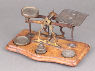 A set of Edwardian postal scales on a serpentine plinth with weights 