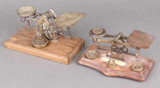 A set of Edwardian postal scales on an oak plinth with 6 graduated weights and 1 other set with serpentine base 