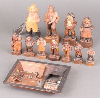 A vintage carved German wooden figure of a fisherman with fish, a quantity of other figures and an interior scene 