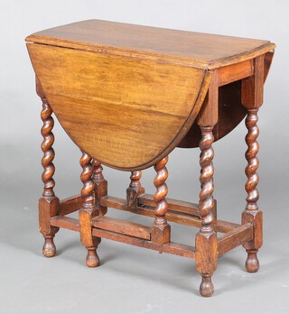 A 1930's oak oval drop flap gateleg dining table on spiral turned supports 73cm h x 73cm w x 35cm 