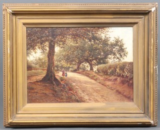 T.F.W., British School, 19th Century oil on canvas, two Figures on a Country Lane, monogrammed, 24cm x 34cm, within a gilt frame 