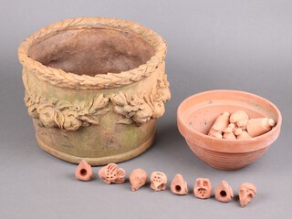 A circular fibreglass, terracotta effect, urn with cast fruit decoration 22cm h x 32cm, together with 10 circular terracotta pea/tomato cane finials and 9 others in the form of animals