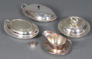 An oval silver plated twin handled entree dish and cover, 2 others and a sauce boat and stand 