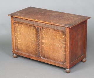 A 1930's oak coffer with hinged lid, on bun feet 59cm h x 92cm w x 45cm d 