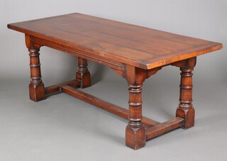 A 17th Century style oak refectory dining table, the top formed of 4 planks, raised on 4 turned supports with H framed stretcher 77cm h x 200cm l x 87cm w 