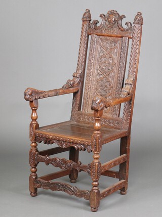 A Victorian, 17th Century style, carved oak Wainscot chair with solid seat, the crest carved a mask and dated 1628, having a carved panel to the side with Green Man arms, raised on turned and block supports 127 cm h x 61cm w x 53cm d (seat 30cm x 28cm) 