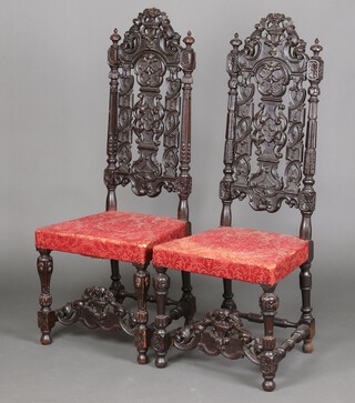 A pair of Victorian ebonised carved and pierced oak Carolean style high back dining chairs with lidded urn crest, square fluted columns to the sides, overstuffed seats, pierced and carved stretcher to the front 125cm h x 49cm w x 42cm d 