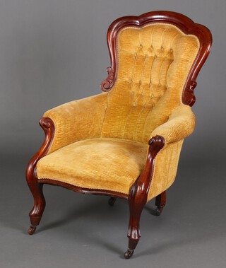A Victorian mahogany show frame armchair upholstered in mustard buttoned material, the seat of serpentine outline, raised on cabriole supports with ceramic casters 104cm h x 69cm w x 50cm d (seat 35cm x 30cm) 
