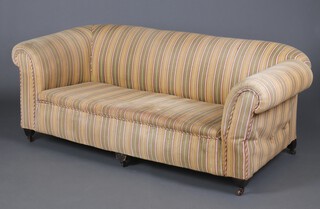 A Chesterfield drop arm settee upholstered in green and gold striped material, raised on square supports with brass casters 69cm h x 184cm w x 87cm d