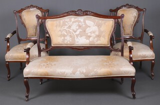 An Edwardian carved mahogany show frame drawing room suite comprising 2 seat sofa 95cm h x 124cm w x62cm d and 2 matching armchairs, upholstered in gold floral patterned material 92cm h x 58cm w x 54cm d (seats 26cm x 38cm) 