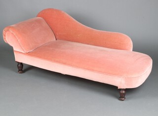 An Edwardian chaise longue upholstered in rose pink material, raised on turned supports 