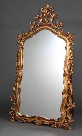 A 1950's Italian arched plate mirror contained in a pierced and carved gilt wood frame with rose decoration to the frame 143cm h x 80cm w 