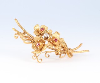 An 18ct yellow gold ruby and diamond set floral spray brooch, the diamond 0.05ct, 50mm, 9.1 grams gross