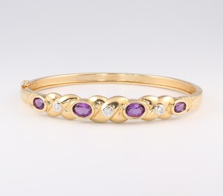 A 14ct yellow gold amethyst and diamond bangle, the amethysts 1.6ct, the diamonds 0.07ct, 6.5cm x 5.5cm, 14.9 grams 