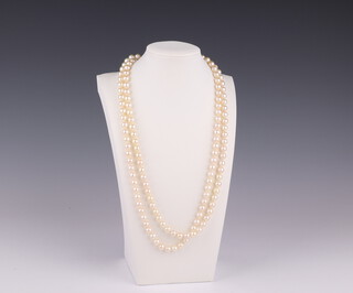 A double strand cultured pearl necklace with an 18ct white gold and diamond set clasp, stamped Manning, each pearl 5mm, the diamonds approx. 0.07ct, 60cm 