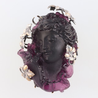 A carved purple glass portrait brooch with metal mounts 5cm 