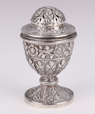 An Indian repousse silver urn shaped pepper decorated with formal flowers 9cm, 102 grams 