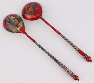 Two Russian silver and enamelled silver spoons with spiral stems, the reverse bowl decorated with a crest and a couple in a garden setting, marked 84 and JA, 13cm