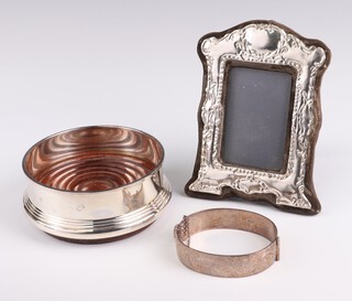 A Georgian style silver coaster Birmingham 1993, 12cm, a ditto photograph frame and a silver bangle (48 grams) 
