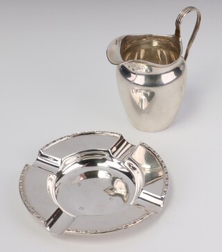 A silver circular ashtray Birmingham 1973, a cream jug, 144 grams