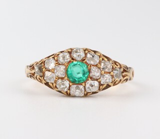 An 18ct yellow gold emerald and diamond cluster ring, the central emerald 0.20ct, the brilliant cut diamonds 0.40ct, size M  