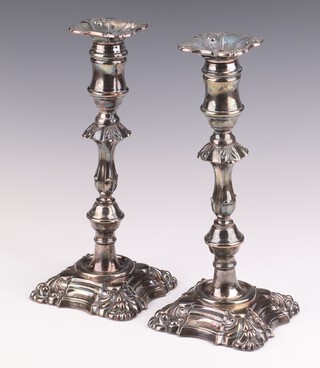 A pair of Georgian style silver candlesticks with waisted stems on weighted scroll bases, having an engraved inscription, Birmingham 1965, 25cm 