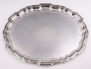 An oval silver salver with Chippendale rim and presentation inscription Birmingham 1953, maker Barker Brothers Silver Ltd., 41cm, 1398 grams 