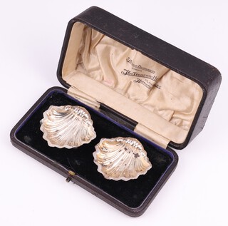 A pair of silver shell shaped table salts Chester 1912 5.5cm, 18 grams, cased
