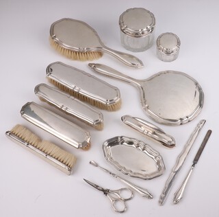 A German 830 standard silver dressing table set comprising pin tray, 2 lidded toilet jars, 4 clothes brushes, hair brush, mirror, nail buffer, scissors, comb back and 2 nail implements 