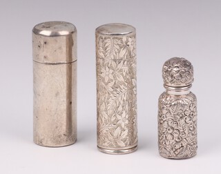 A Victorian cylindrical scent bottle, Chester 1883, 6cm, an engraved ditto London 1896, 6cm and a ditto with hinged lid Birmingham 1899, 5cm