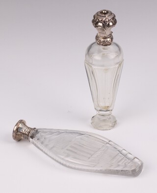 A Victorian silver mounted flat glass scent bottle with silver lid London 1865, 12cm, a tapered ditto with repousse lid 11cm 