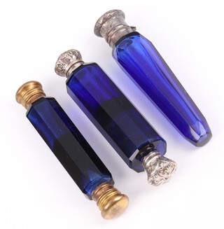 A Victorian silver mounted blue glass tapered scent, rubbed marks (chipped), 10cm, a double ended ditto (unmarked) 10cm and a brass mounted ditto 10cm 