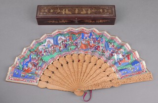 An early 20th Century Chinese boxwood fan decorated with figures at pursuits 26.5cm, contained in a chinoiserie decorated box, the interior decorated with birds and flowers, the exterior with a procession of figures 31cm 