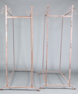 A pair of rectangular wrought iron stands with spiral turned decoration to the sides, raised on scroll supports, 185cm h x 80cm w x 185d and 189cm h x 75cm w x 148cm d