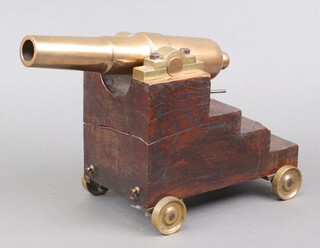 A 19th Century brass barrelled signalling cannon with 32cm brass barrel, raised on a stepped wooden carriage 23cm x 28cm x 14cm 