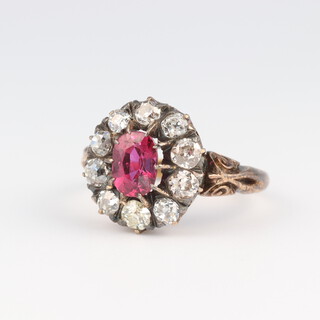 An 18ct yellow gold oval ruby and diamond cluster ring, the centre stone approx. 1ct, the 10 brilliant cut diamonds 0.5ct, size M, 4.2 grams 