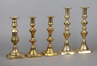 Two pairs of 19th Century brass candlesticks with ejectors 30cm and 25cm and 1 other brass candlestick 25cm 