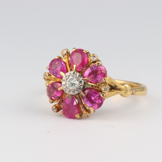 An 18ct yellow gold ruby and diamond cluster ring, the centre diamond 0.07ct, the pear cut rubies 1.8ct, size P, 4.8 grams 