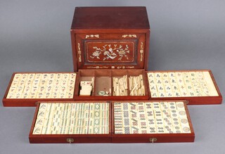 A bamboo and bone Mahjong set comprising 148 tiles and numerous scoring sticks, all contained within a 5 drawer cabinet, the front inlaid mother of pearl 8cm h x 25cm w x 16cm d