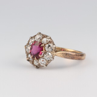 An 18ct yellow gold ruby and diamond cluster ring, the centre ruby 0.75ct, the brilliant cut diamonds approx. 0.45ct, size K 1/2, 3.4 grams