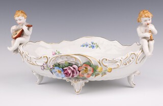 A German Von Schierholz twin handled boat shaped porcelain bowl supported by 2 seated musicians, the interior painted flowers 