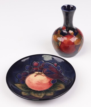 A modern Moorcroft dish the blue ground decorated with a bird and peach, modern impressed mark 12cm, together with a baluster vase decorated with fruits 9cm 