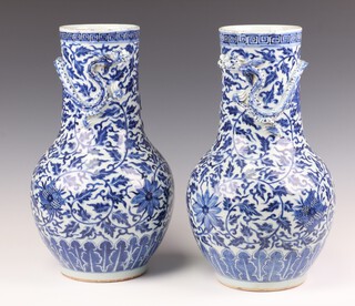 A pair of early 20th Century Chinese oviform vases with moulded decoration of dragons on a formal floral ground, 35cm 