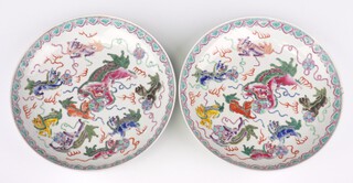 A pair of early 20th Century Chinese shallow dishes decorated with Shi Shi, 27cm 