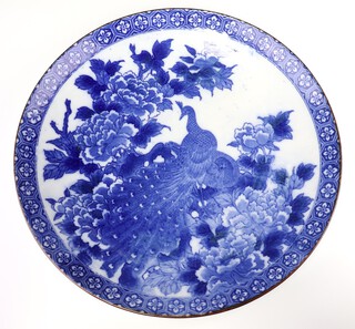 An early 20th Century Chinese blue and white transfer print dish decorated with a peacock amongst flowering peony 45cm 