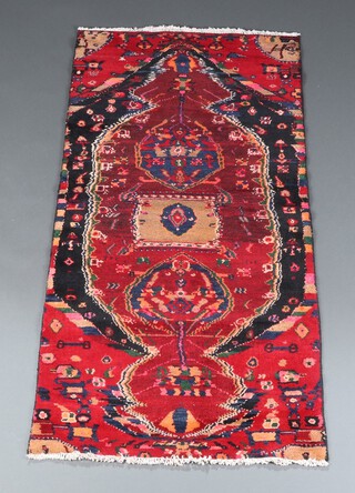 A red, blue and tan ground Afghan rug with 2 stylised medallions to the centre 170cm x 81cm 