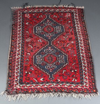 A red and black ground Afghan rug with 2 stylised medallions to the centre within a multi row border 150cm x 108cm 