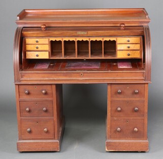 A Victorian mahogany cylinder bureau with 3/4 gallery, the interior fitted pigeon holes and 10 short drawers, with pull out writing surface, the centre having a ratcheted pull up slope, the base fitted 6 drawers 122cm h x 119cm w x 61cm d 
